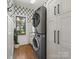 Modern laundry room features a stacked washer and dryer and storage cabinets at 19000 Hodestone Mews Ct, Davidson, NC 28036