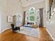 Light-filled living room with a large arched window, high ceilings, and stylish furnishings at 19000 Hodestone Mews Ct, Davidson, NC 28036