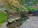 Serene pond with rocks, moss, small waterfall, and colorful foliage creating an inviting outdoor space at 19000 Hodestone Mews Ct, Davidson, NC 28036