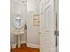 Elegant powder room featuring a pedestal sink, decorative mirror, and hardwood floors at 19000 Hodestone Mews Ct, Davidson, NC 28036