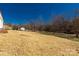 A spacious backyard with a gentle slope and mature trees in the background at 2005 Sugar Hill Rd, York, SC 29745