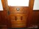 A wooden door with a unique circular design, surrounded by detailed trim and paneling at 201 W Rice St, Landis, NC 28088
