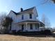 Side view of a charming two-story home with a wrap-around porch and well-maintained yard at 201 W Rice St, Landis, NC 28088