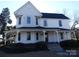 Charming two-story home featuring a welcoming wrap-around porch and mature landscaping at 201 W Rice St, Landis, NC 28088