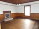Living room featuring a decorative light fixture, a fireplace, and classic wood paneling at 201 W Rice St, Landis, NC 28088