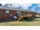 Backyard view of brick home with metal roof and wooden deck with stairs at 2028 Hendil St, Conover, NC 28613