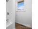 Bathroom featuring updated shower and fixtures, a window allowing natural light and new flooring at 2028 Hendil St, Conover, NC 28613