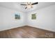 Bright bedroom featuring new wood floors, white walls, ceiling fan, and two windows letting in natural light at 2028 Hendil St, Conover, NC 28613