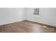 Sunlit bedroom featuring new wood floors and a large window overlooking the backyard at 2028 Hendil St, Conover, NC 28613