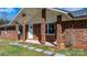 Inviting brick front porch with white columns, stone walkway and mature landscaping at 2028 Hendil St, Conover, NC 28613