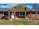 Inviting brick front porch with white columns, stone walkway and mature landscaping at 2028 Hendil St, Conover, NC 28613