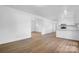 Bright living room featuring new wood floors, white walls, and updated fixtures and a view into the modern kitchen at 2028 Hendil St, Conover, NC 28613