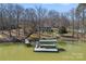 Aerial view of lake house with a private dock and boat lift, surrounded by trees and waterfront at 213 Patternote Rd, Mooresville, NC 28117
