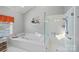 Bright bathroom with a soaking tub, a tiled shower, and a large window at 213 Patternote Rd, Mooresville, NC 28117