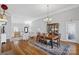 Bright dining room with hardwood floors, statement chandelier and large china cabinet adjacent to entry and staircase at 213 Patternote Rd, Mooresville, NC 28117