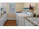 Laundry room with a modern washer and dryer set, granite countertop, sink, and wooden floors at 213 Patternote Rd, Mooresville, NC 28117