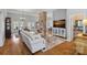 Spacious open-concept living room featuring hardwood floors, a stone fireplace, and lots of natural light at 213 Patternote Rd, Mooresville, NC 28117