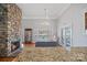 Open living room showcasing a stone fireplace, hardwood flooring, a lake view from the bay window, and a chandelier at 213 Patternote Rd, Mooresville, NC 28117