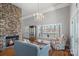 Bright living room showcasing a stone fireplace, hardwood flooring, a lake view from the bay window, and a chandelier at 213 Patternote Rd, Mooresville, NC 28117
