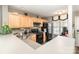 Well-lit kitchen with wood cabinets, sleek black appliances, and practical countertop space at 2511 Brackley Nw Pl # 1013, Concord, NC 28027
