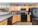Functional kitchen featuring wood cabinetry, a black range, and modern wood-look flooring at 2511 Brackley Nw Pl # 1013, Concord, NC 28027