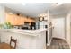 Cozy kitchen featuring wood cabinets, black appliances, and a breakfast bar for casual dining at 2511 Brackley Nw Pl # 1013, Concord, NC 28027