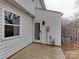 A view of the white siding, window, and glass door in the backyard, with a small concrete area and AC unit at 307 French St, Charlotte, NC 28216