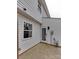 A view of the white siding, window, and glass door in the backyard with a small concrete area at 307 French St, Charlotte, NC 28216