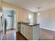 Kitchen island connects to dining area, boasting modern fixtures, dark countertops, and stainless steel appliances for seamless living at 307 French St, Charlotte, NC 28216