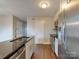 Open-concept kitchen with stainless steel appliances, dark countertops, and bright cabinets provides a modern, functional layout at 307 French St, Charlotte, NC 28216