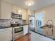 Updated kitchen showcasing stainless steel appliances, tiled backsplash, and sleek countertops with an adjacent laundry area at 307 French St, Charlotte, NC 28216