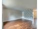 Open-concept living room featuring wood flooring, decorative wall, and neutral paint at 307 French St, Charlotte, NC 28216