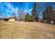 View of the exterior showing a detached garage, trees, and a large grassy field at 4238 Johnson Bridge Rd, Hickory, NC 28602