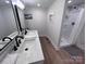 Well-lit bathroom featuring double sinks, stylish black fixtures, and a shower, creating a modern and clean space at 4317 Ruskin Dr, Charlotte, NC 28209
