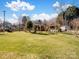 Large backyard with a lush lawn, mature trees, fence, shed, and pergola with hammock at 4540 Hounds Run Dr, Matthews, NC 28105
