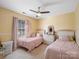 Bright bedroom with two twin beds, ceiling fan, and large window at 4540 Hounds Run Dr, Matthews, NC 28105