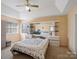 Comfortable bedroom with a tray ceiling, ceiling fan, and built-in storage and display shelves at 4540 Hounds Run Dr, Matthews, NC 28105