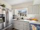 Bright kitchen features white cabinets, stainless steel refrigerator, and a view from the window over the sink at 4540 Hounds Run Dr, Matthews, NC 28105