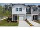 Charming townhouse with a two-car garage, a gray and white facade, and well-manicured landscaping at 5009 Kellaher Pl, Charlotte, NC 28216