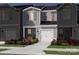 Charming gray two-story townhome featuring a one-car garage and beautifully landscaped front yard at 5013 Kellaher Pl, Charlotte, NC 28216
