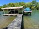 View of a covered boat dock with two boats on a clear lake at 5153 Glenwood St, Sherrills Ford, NC 28673