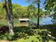 Scenic lake view with a boat dock, set against a backdrop of lush greenery and clear blue skies at 5153 Glenwood St, Sherrills Ford, NC 28673