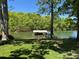 Scenic lake view featuring a covered boat dock, fire pit, and lush greenery at 5153 Glenwood St, Sherrills Ford, NC 28673