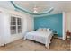 Cozy bedroom featuring a tray ceiling, a ceiling fan, and a large window at 543 Weavers Xing, Fort Mill, SC 29715