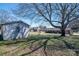 Large backyard with mature trees, detached garage, and a view of the back of the house at 605 Castlewood Dr, Gastonia, NC 28056