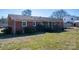 A backyard featuring a covered patio area, lawn, and mature landscaping at 605 Castlewood Dr, Gastonia, NC 28056