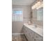 Well-lit bathroom featuring a vanity with a sink, white cabinets, and a large window at 605 Castlewood Dr, Gastonia, NC 28056