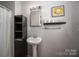 Well-lit bathroom features pedestal sink, open shelving, and stylish decor at 605 Castlewood Dr, Gastonia, NC 28056