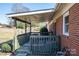 Cozy covered patio, perfect for enjoying the outdoors, featuring green railings and brick exterior at 605 Castlewood Dr, Gastonia, NC 28056