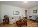 Warm living room featuring a floral sofa, wood laminate floors, and plenty of seating at 605 Castlewood Dr, Gastonia, NC 28056